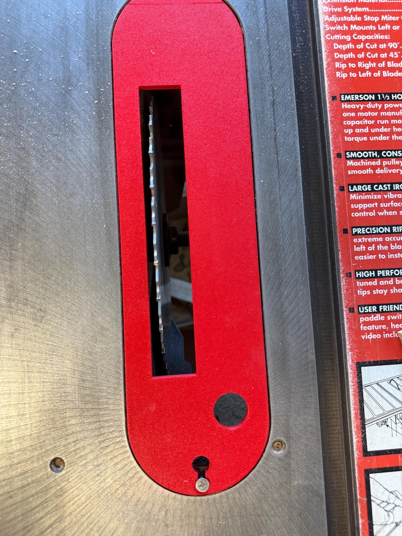 May include: Close-up of a red and silver table saw with a blade exposed. The saw has a large cast iron base and a precision rip fence. The text on the saw reads "EMERSON 1 1/2 HP Heavy-duty power with one motor manufactured with a capacitor run motor. Smooth, consistent torque under the heavy load."