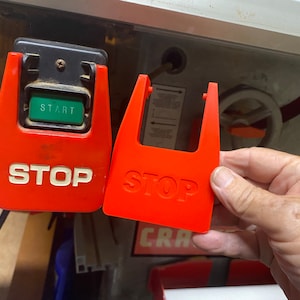 May include: Two red safety switches for a table saw. The switch on the left has a green button labeled "START". Both switches have the word "STOP" in white lettering.