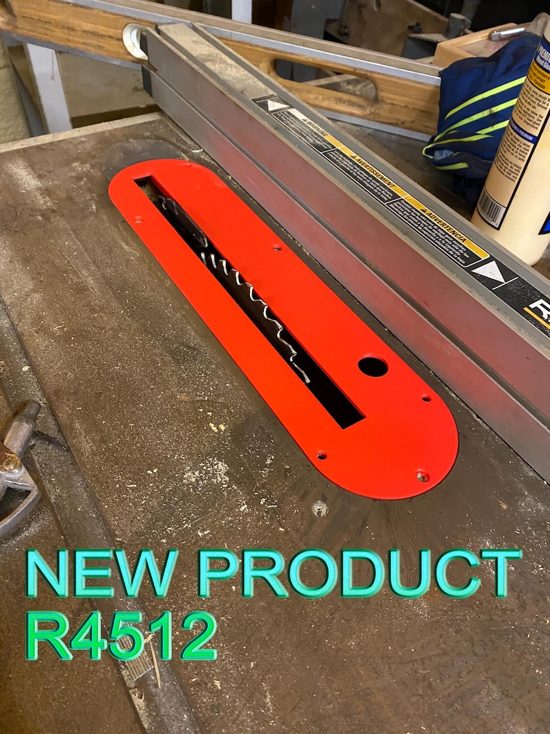 May include: A bright red table saw insert with a black blade opening. The insert is labeled "R4512" and "NEW PRODUCT" in green text. The saw is on a wooden surface.