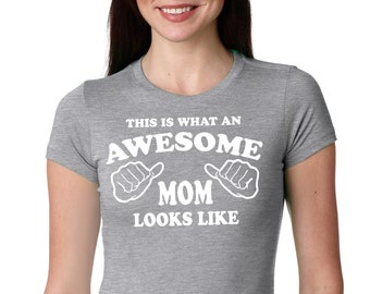 Puede incluir: Camiseta gris con texto blanco que dice "This is what an awesome mom looks like" con dos pulgares blancos hacia arriba apuntando a la izquierda y derecha de la palabra "mom".