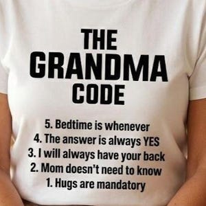 May include: A white t-shirt with the text "THE GRANDMA CODE" in bold black letters. Below the title are five rules, including "Hugs are mandatory" and "Bedtime is whenever."