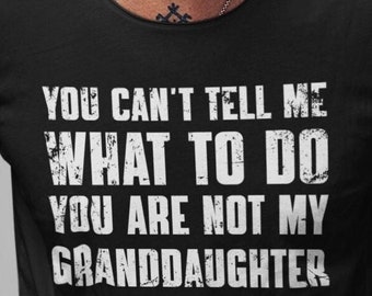 May include: Black t-shirt with the white text "YOU CAN'T TELL ME WHAT TO DO YOU ARE NOT MY GRANDDAUGHTER". The shirt has a crew neck and is worn by a person with a silver chain necklace and a small tattoo.