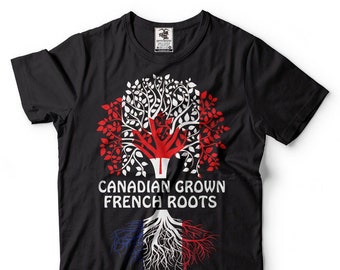 Puede incluir: Camiseta negra con un gráfico de un árbol con hojas rojas y blancas. Las raíces del árbol están en los colores de la bandera francesa. El texto "CANADIAN GROWN FRENCH ROOTS" está impreso en la camiseta.