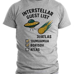 Puede incluir: Camiseta gris con la frase "INTERSTELLAR GUEST LIST" en negro. La camiseta presenta un dibujo de un OVNI y un cometa. Debajo, casillas de verificación con los nombres 'OUMUAMUA, BORISOV y ATLAS.