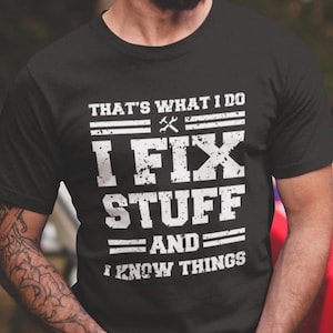 May include: Black t-shirt with white text that reads "That's what I do I fix stuff and I know things". The text is in a distressed font and includes a wrench and screwdriver graphic.