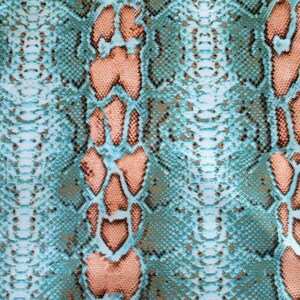 May include: A fabric featuring a repeating snakeskin pattern in shades of teal, light blue, and peach. The design consists of textured, scale-like shapes outlined in dark brown, creating a vertical orientation with alternating color bands.