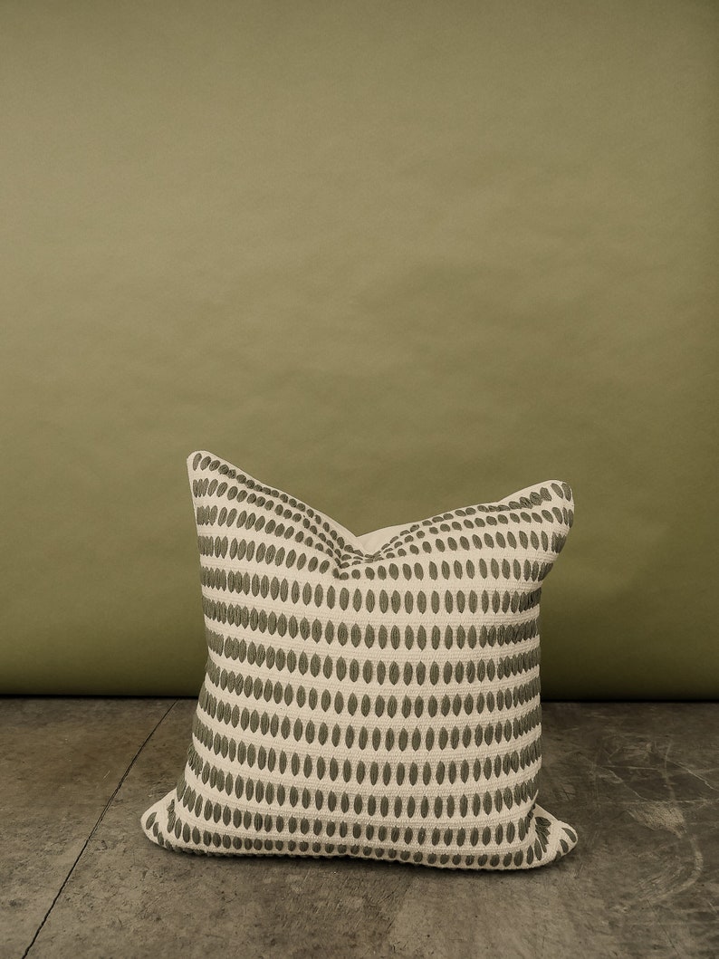 Our selfoss pillow cover. A white/cream pillow cover with olive green details.