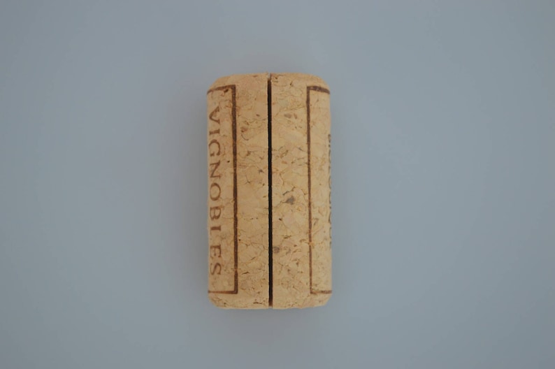 Cork card holder from different vineyards. Used for rustic wedding cards, wedding booths, anniversaries, parties and table decorations. on a wooden base with decorative flowers. for wedding favors