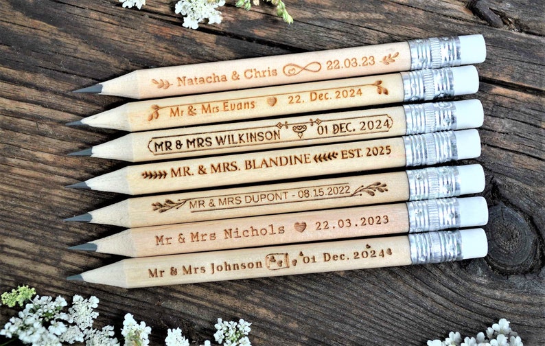 Personalized mini golf pencils, used for wedding favors and decorations at country style wedding, with white eraser, on wooden table with decorative flowers. An excellent gift for guests and all your loved ones.