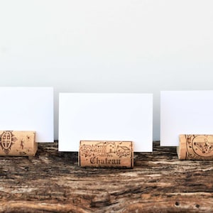 Cork card holder from different vineyards. Used for rustic wedding cards, wedding booths, anniversaries, parties and table decorations. on a wooden base with decorative flowers. for wedding favors