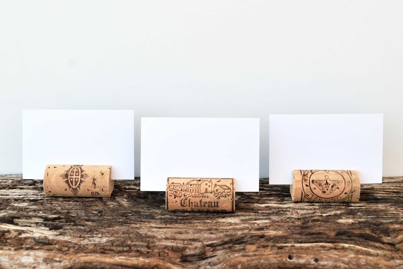 Cork card holder from different vineyards. Used for rustic wedding cards, wedding booths, anniversaries, parties and table decorations. on a wooden base with decorative flowers. for wedding favors