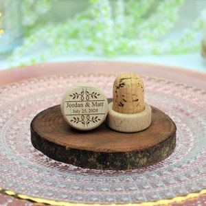 Personalized wine stopper, laser engraved, design 5, perfect for decorating rustic style weddings, parties and anniversaries. Made of wood and cork, on a table with decorative flowers. An excellent wedding favor for guests