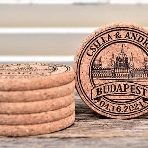 Personalized engraved cork coasters Budapest design, used for rustic wedding decorations, wedding favors and parties. They are made of high quality natural cork. On a wooden table. An excellent gift for guests and loved ones.