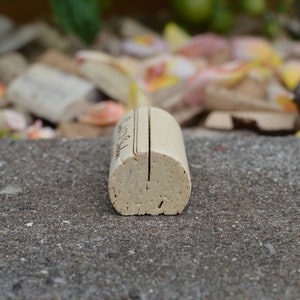 Personalized Cork Place Card Holder, Laser Engraved. Used for Rustic Wedding Place Cards, Wedding Booth, Parties and Table Decorations. on a wooden base with decorative flowers. for wedding favors