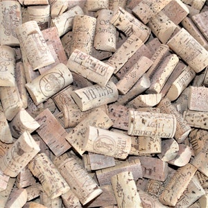 May include: A close-up image of a pile of used wine corks. The corks are various shades of brown and beige, and some have text and logos printed on them.