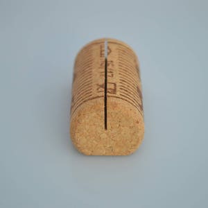 Cork card holder from different vineyards. Used for rustic wedding cards, wedding booths, anniversaries, parties and table decorations. on a wooden base with decorative flowers. for wedding favors