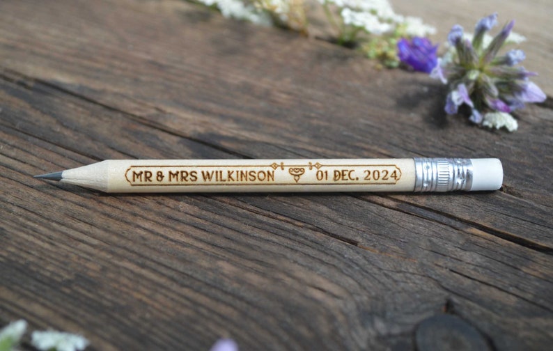 Personalized mini golf pencils, used for wedding favors and decorations at country style wedding, with white eraser, on wooden table with decorative flowers. An excellent gift for guests and all your loved ones.