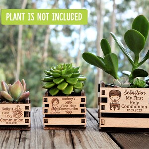 Engraved mini pots, personalized, used for first communion and parties. Made of wood. With a succulent plant, on a wooden table. Used for first communion party favors