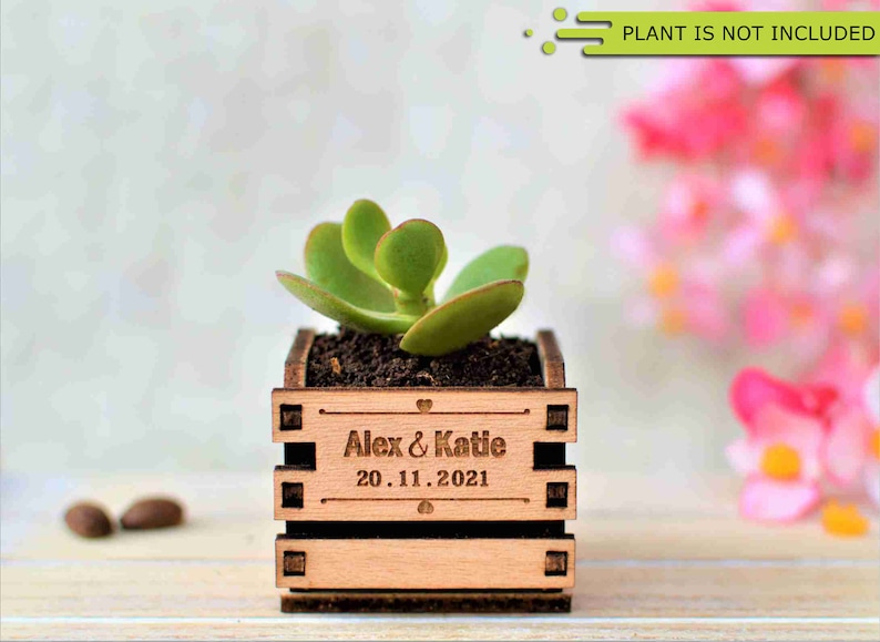 Engraved personalized mini pots, used for wedding favors, rustic style wedding decorations and your home. It is made of wood, with a succulent plant on a wooden table decorated with flowers. An excellent gift for guests and all your loved ones.