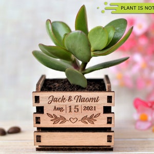 Engraved personalized mini pots, used for wedding favors, rustic style wedding decorations and your home. It is made of wood, with a succulent plant on a wooden table decorated with flowers. An excellent gift for guests and all your loved ones.