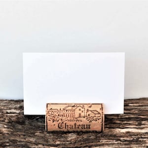 Cork card holder from different vineyards. Used for rustic wedding cards, wedding booths, anniversaries, parties and table decorations. on a wooden base with decorative flowers. for wedding favors