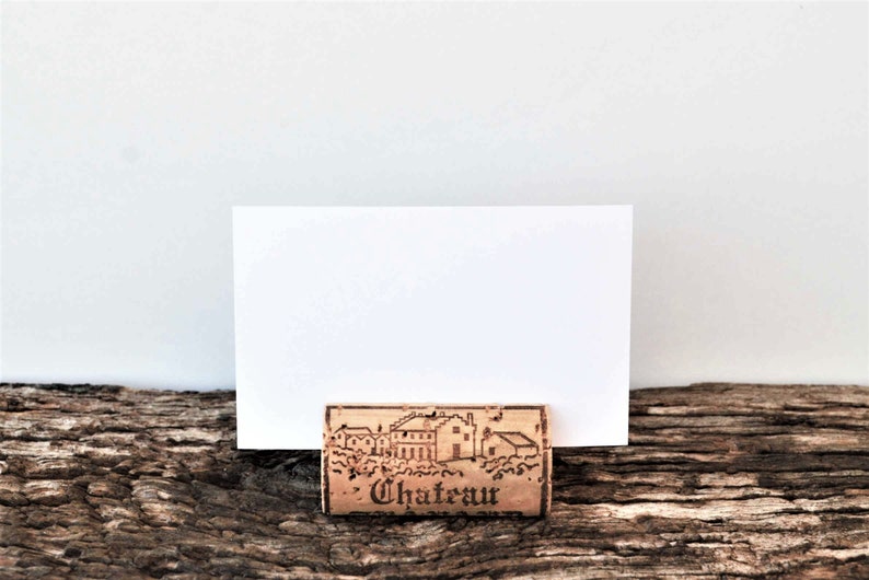 Cork card holder from different vineyards. Used for rustic wedding cards, wedding booths, anniversaries, parties and table decorations. on a wooden base with decorative flowers. for wedding favors