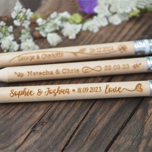 Personalized mini golf pencils, used for wedding favors and decorations at country style wedding, with white eraser, on wooden table with decorative flowers. An excellent gift for guests and all your loved ones.