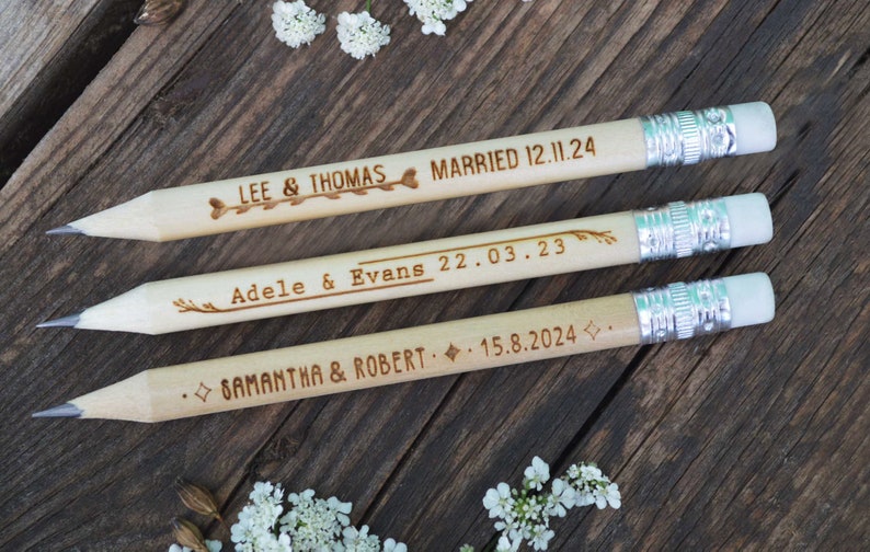 Personalized mini golf pencils, used for wedding favors and decorations at country style wedding, with white eraser, on wooden table with decorative flowers. An excellent gift for guests and all your loved ones.