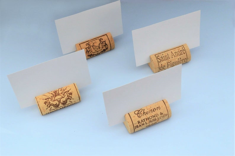 Cork card holder from different vineyards. Used for rustic wedding cards, wedding booths, anniversaries, parties and table decorations. on a wooden base with decorative flowers. for wedding favors