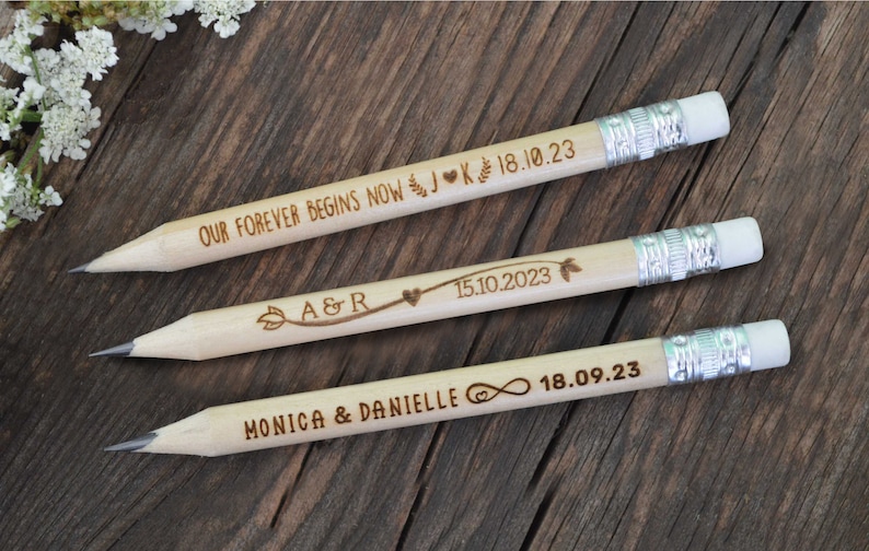 3 personalized mini golf pencils, used for wedding favors and decorations at country style wedding, with white eraser, on wooden table with decorative flowers. An excellent gift for guests and all your loved ones.