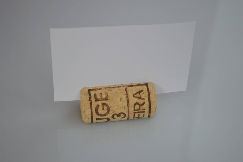 Cork card holder from different vineyards. Used for rustic wedding cards, wedding booths, anniversaries, parties and table decorations. on a wooden base with decorative flowers. for wedding favors