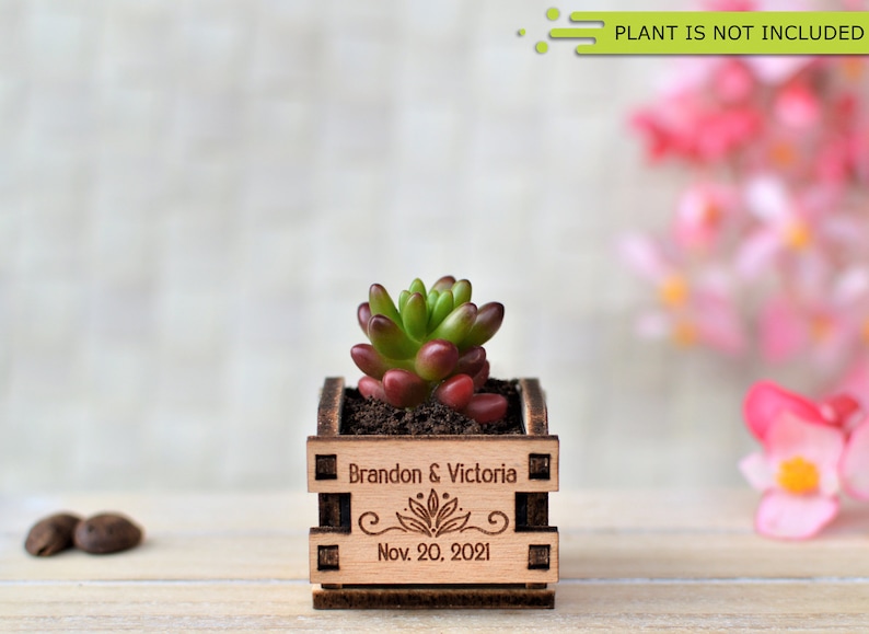 Engraved personalized mini pots, used for wedding favors, rustic style wedding decorations and your home. It is made of wood, with a succulent plant on a wooden table decorated with flowers. An excellent gift for guests and all your loved ones.