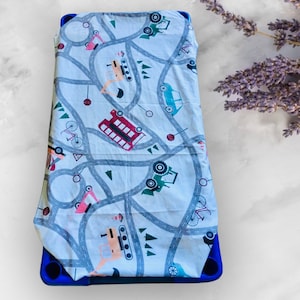 May include: White fitted sheet with a road and vehicle print. The print features a variety of vehicles including cars, trucks, buses, and bicycles. The sheet is on a blue mattress.