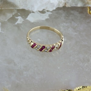 Peut inclure: Une bague en or avec une rangée diagonale de rubis rouges et de diamants blancs.