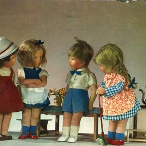 Puede incluir: Cuatro muñecas, dos niñas y dos niños, están de pie en una habitación. Las muñecas están vestidas con diferentes atuendos. Una niña lleva un vestido rojo, otra lleva un vestido azul y blanco, y un niño lleva una camisa azul y pantalones cortos azules. El otro niño lleva una camisa blanca y pantalones cortos azules. Las muñecas están de pie frente a una mesa con un jarrón de flores.