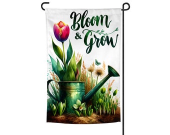 May include: A garden flag with a watercolor design of a watering can, tulips, and other flowers. The text "Bloom & Grow" is written in green cursive lettering.