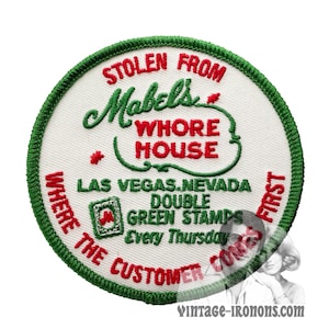 Può includere: Una toppa rotonda bianca ricamata con cuciture verdi. Il testo recita "Stolen from Mabel's Whore House, Las Vegas, Nevada, Double Green Stamps Every Thursday, Where the Customer Comes First".