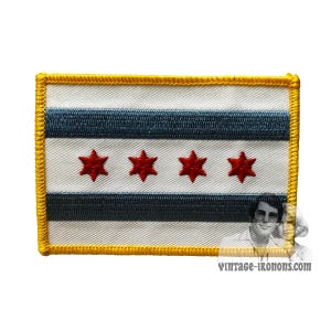May include: A white and blue embroidered patch with a yellow border and four red stars. The patch features the Chicago flag.
