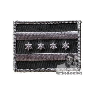 May include: A gray embroidered patch with the Chicago flag design. The flag has four white stars on a black background with two white stripes.