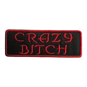 May include: A black embroidered patch with red stitching. The patch says "CRAZY BITCH" in a stylized font.