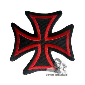 Può includere: Toppa ricamata a forma di croce nera e rossa. La toppa presenta una croce nera con un bordo rosso. È progettata per essere cucita o stirata su abiti o accessori. Il sito web vintage-ikonons.com è visibile nell'immagine.