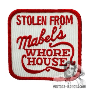 Peut inclure: Écusson brodé rouge sur fond blanc. L'écusson porte l'inscription "Stolen from Mabel's Whore House".