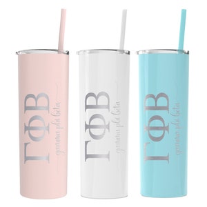 May include: Three stainless steel tumblers with lids and straws. The tumblers are pink, white, and blue. Each tumbler has the Greek letters "ΓΦΒ" and the words "gamma phi beta" engraved on the side.