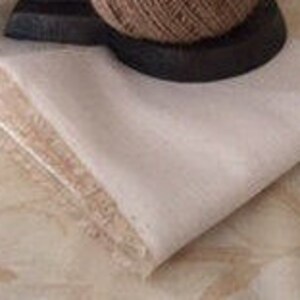 May include: A stack of white fabric squares, folded in half, with a frayed edge. The fabric is smooth and appears to be linen or cotton.