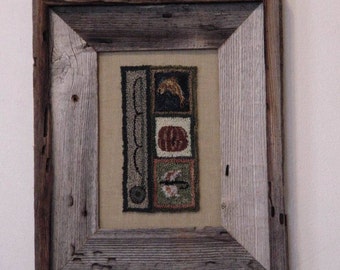 May include: A framed needlepoint artwork with a rustic wood frame. The artwork features a series of colorful squares with different designs, including a fish, a pumpkin, and a bird.