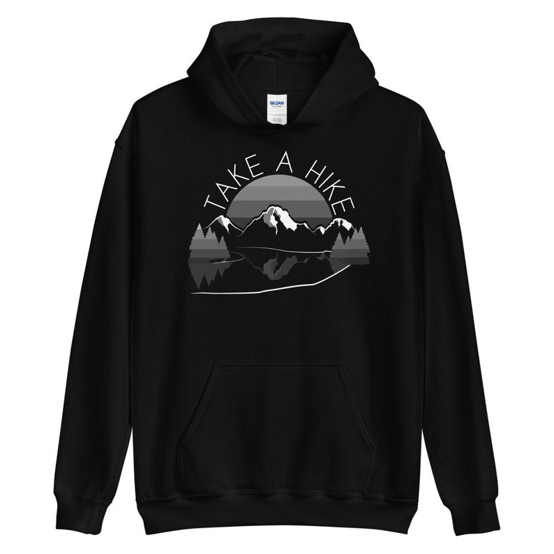 Puede incluir: Sudadera con capucha negra con un gr&aacute;fico blanco de una cordillera y un lago con el texto "Take a Hike" encima.