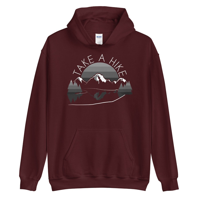 Puede incluir: Sudadera con capucha color burdeos con un gr&aacute;fico blanco de monta&ntilde;as y un lago con el texto "Take a Hike" en un c&iacute;rculo.