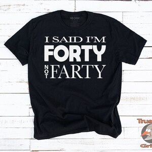 May include: Black t-shirt with white text that reads "I said I'm forty not farty".