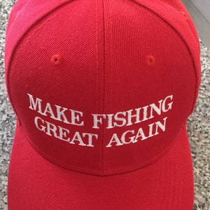 May include: Red baseball cap with a white embroidered phrase "MAKE FISHING GREAT AGAIN".