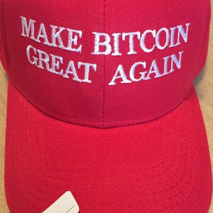 May include: Red baseball cap with white embroidered text that reads "MAKE BITCOIN GREAT AGAIN".